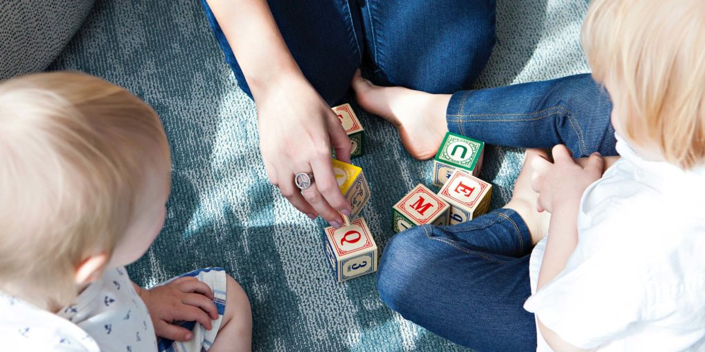 image of children playing with blocks with an adult