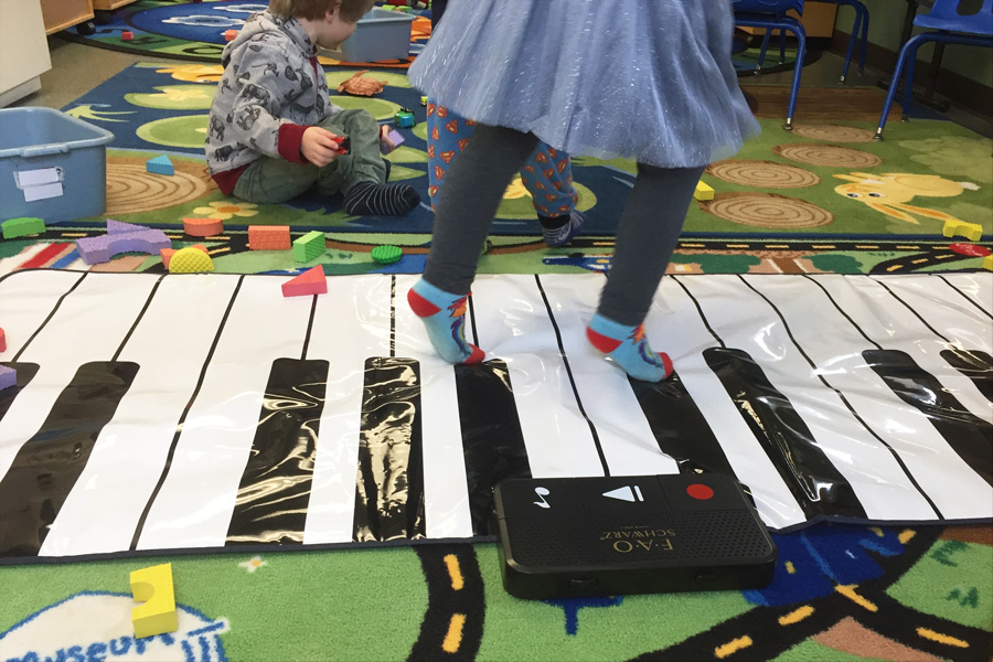 Child playing floor piano